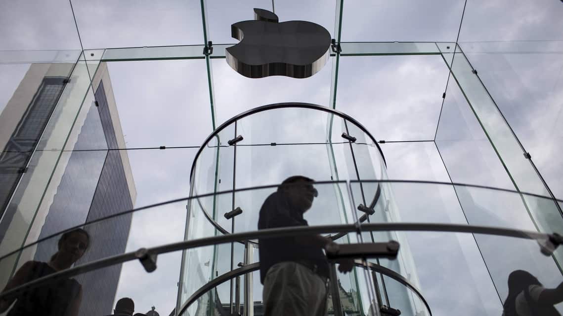 FILE: Customers enter the Apple store on 5th Avenue beneath an Apple logo in the Manhattan borough of New York City, July 21, 2015.